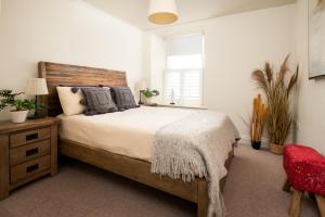 a bedroom with a large bed and a red chair at Hide hill ,2 bedroom central apartment in Berwick-Upon-Tweed