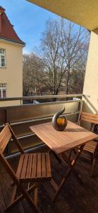 a wooden table on a balcony with an orange on it at Tipp - Halle idyllisch am Fluss in Halle an der Saale