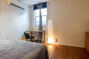 a bedroom with a bed and a chair and a window at Downtown Retreat-Spacious Rooms with Shared Kitchen & Bath in Toronto