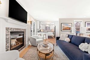a living room with a blue couch and a fireplace at Private deck walk to Commercial Street in Provincetown +35 photos
