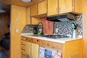 a kitchen with wooden cabinets and a stove at Boulderdash "Stella" The vintage trailer in Bandera