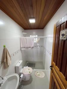 a bathroom with a toilet and a sink at Casa de campo com piscina em meio à natureza in Campo Magro