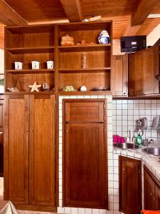 a kitchen with wooden cabinets and a sink at splendido open space in Villa Veronica Porto Istana in Porto Istana