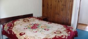 a bed in a bedroom with a floral bedspread at departamento en Valeria del mar in Valeria del Mar