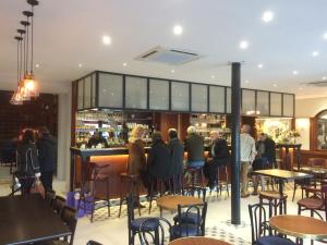 a group of people standing around a bar in a restaurant at Hotel La Regence in Villefranche-sur-Mer