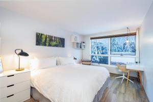 a bedroom with a bed and a desk and a window at One block walk to gondola, ski lockers downstairs, River Trail close by! in Telluride