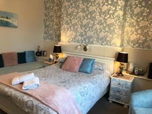a bedroom with a bed and two tables with lamps at Cornubia Guest House in Weymouth