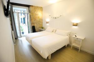 Un dormitorio con una gran cama blanca y una ventana en Artea Narrika, en San Sebastián