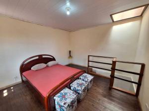 a bedroom with a bed and a wooden floor at Casa aconchegante em Curitiba in Curitiba