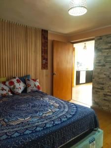a bedroom with a bed with a blue comforter at Samay Wasi in Ayacucho