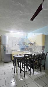 a kitchen with a table and chairs and a refrigerator at Casa Memmar in Acapulco