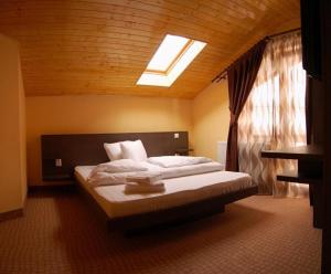 a bedroom with a large bed with a skylight at Vila Platoul Soarelui in Straja