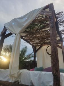 Una cama con dosel blanco encima. en The Epiphany Home in the Countryside, en General Las Heras