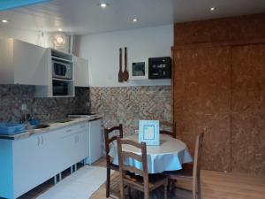 a kitchen with a table and chairs in a kitchen at O Canto do Melro, Guest House in Cortegaça