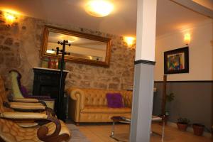 a living room with a couch and a mirror at Hotel Clermont Montmartre in Paris