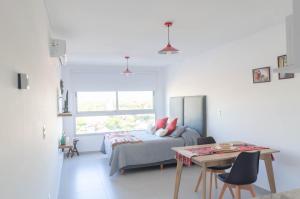 a bedroom with a bed and a table and a window at Koñi Nqn in Neuquén