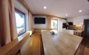 a living room with a wooden table and a kitchen at Ferienwohnungen Guglhof Mariapfarr in Mariapfarr