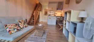 ein Wohnzimmer mit Sofa und eine Küche in der Unterkunft Copains Cabanon in Frontignan