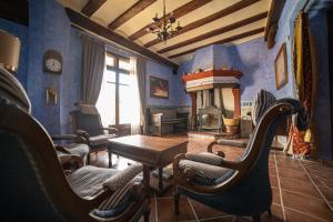 a living room with blue walls and a table and chairs at Hotel SPA Don Iñigo de Aragón in Las Cuevas de Cañart