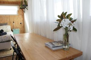 a vase of flowers sitting on a wooden table at Tree House Jan Juc in Torquay