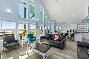 a living room with a couch and a table at Beachfront HotTub Gameroom CargoLift - SandyCheeks in Bolivar Peninsula