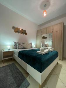 a bedroom with a large bed with a blue blanket at Élégance familiale à Skhirate près de la plage et la ville in Skhirat
