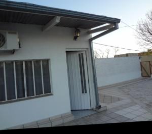 a white house with a door and a balcony at Departamento Storni Rafaela in Rafaela