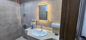 a bathroom with a sink and a mirror at Madinaty apartment 4 شقة فندقية مفروشة سوبر لوكس في مدينتي in Madinaty