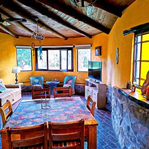 a kitchen and living room with a table and chairs at misky wayra in Capilla del Monte