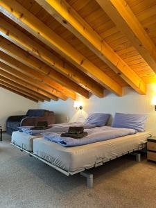 two beds in a room with wooden ceilings at Touristenheim Bergfreude in Leukerbad