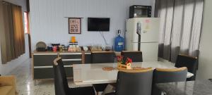 a dining room with a table and a refrigerator at Apartamento grande na Pedreira no coração da Cop 30 in Belém