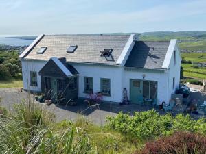 a white house on top of a hill at Bay View Hideaway Lahinch in Lahinch