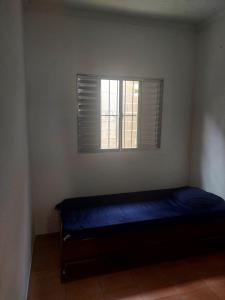 Una pequeña habitación con una cama y una ventana. en Casa de Praia Ubatuba, en Ubatuba