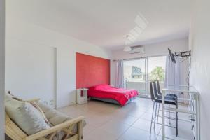 a living room with a couch and a red wall at Departamentos Temporales Tigre in Tigre