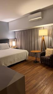 Una habitación de hotel con una cama, una mesa y un sofá. en M N Flats - Quarto Dentro Do Hotel WB WTC Berrini, en São Paulo