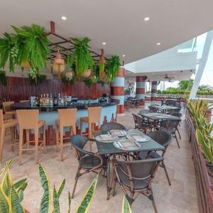 a restaurant with tables and chairs and a bar at Emmaus in Cartagena de Indias