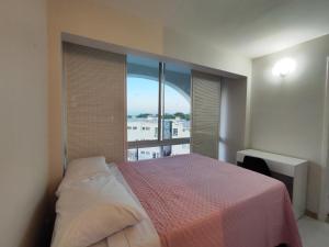Un dormitorio con una cama y una ventana grande. en Apartamento próximo à praia, en Lauro de Freitas 14 fotos más