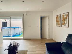 ein Wohnzimmer mit einer Couch und einer Glasschiebetür in der Unterkunft DOMUS AGER - Casa rural en Mahora in Mahora