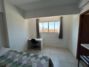 a bedroom with a bed and a desk and a window at Spot Miami in Araraquara
