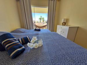 a bedroom with a blue bed with blue sheets and flowers at Casa do Pescador - Paripueira in Paripueira +24 photos