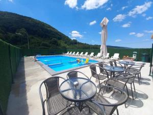 a patio with tables and chairs next to a swimming pool at Vikendica, Bazen, Šedrvan, Rafting na Uni, Quad in Bihać