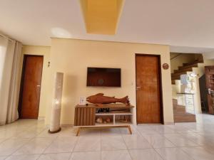 a living room with a tv on a wall at Casa do Pescador - Paripueira in Paripueira