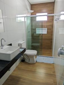 a bathroom with a toilet and a sink and a shower at Casa para temporada 2-Rio da ville in Porto Seguro +8 photos