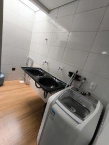 a bathroom with a sink and a washing machine at Casa para temporada 2-Rio da ville in Porto Seguro