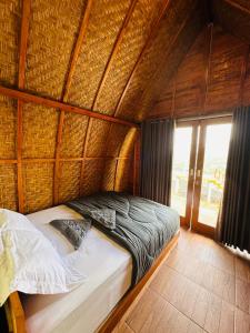 a bedroom with a bed in a bamboo room at Pinggan Campside Glamping in Baturaja