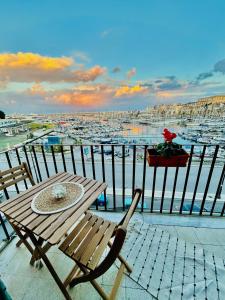 a table and chairs on a balcony with a harbor at CalaMia in Palermo
