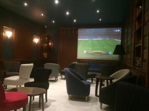 a bar with chairs and a large screen with a football game at Hotel La Regence in Villefranche-sur-Mer