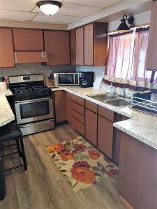 a kitchen with wooden cabinets and a rug on the floor at Lakeshore Motel Ice Lake in Iron River