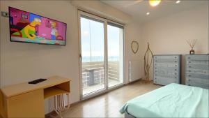 a bedroom with a bed and a television on the wall at Lungomare 70 in Marzocca di Senigallia