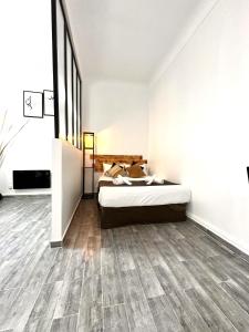 a bedroom with a bed and wooden floors at studio au cœur d'Alger centre in Sidi MʼHamed